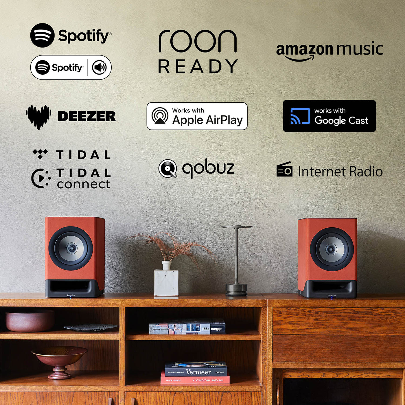 Technics CX700 Speakers on console table in a living room setting with various logos for compatibility: Spotify, Roon Read, Amazon Music, Works with Google Cast, Internet Radio, Qobuz, Tidal, Tidal Connect, Deezer